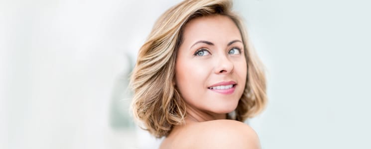 Close up portrait of a woman looking over her shoulder and smiling