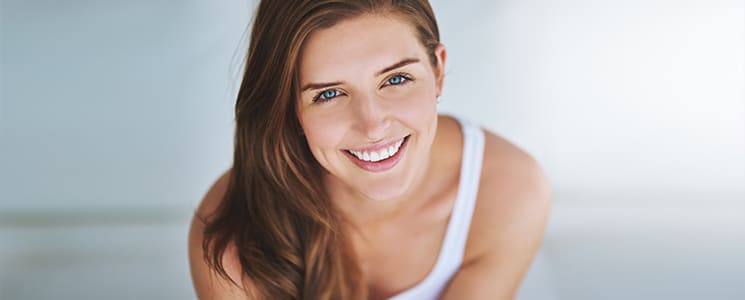 close up image of a woman smiling and leaning forward toward the camera