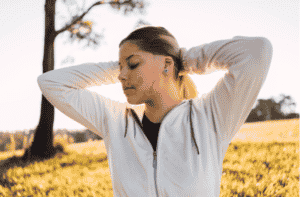 beautiful teenage girl with a birthmark on her face with her eyes closed at sunset.