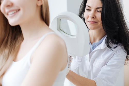 Concentrated dermatologist using medical loupe in the clinic