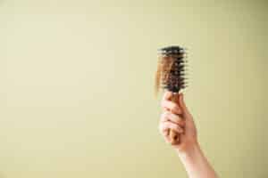 Hand,Of,Woman,With,Hair,Loss,Problem,Holding,Brush,On