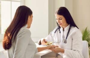 Female dermatologist inspecting skin of woman