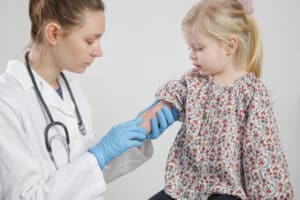 Dermatology looking at eczema flareup on small girl's arm